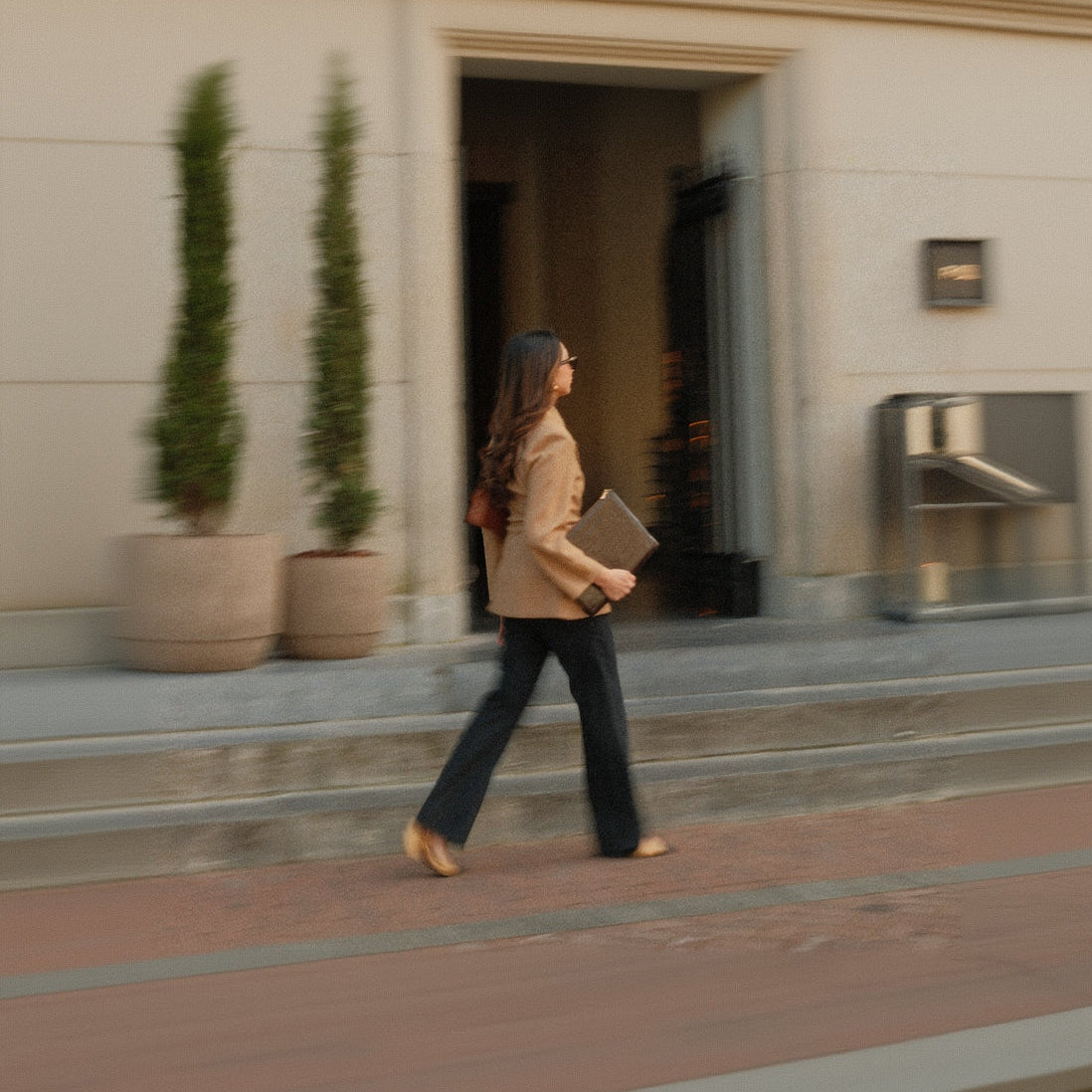 Woman walking with a fashionable laptop sleeve on her way to work